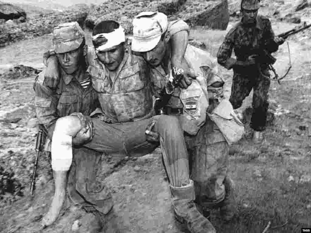 Fighters of the presidential guard carrying their wounded to a shelter in Kurgan-Tyube near Dushanbe, on August 11, 1997. More than 150,000 people were killed in the five-year conflict.