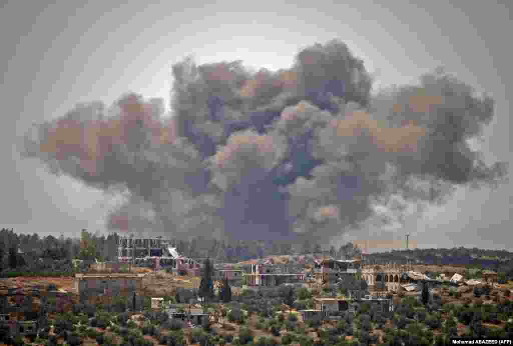 Smoke rises above opposition-held areas in the city of Daraa during air strikes by Syrian regime forces on June 28. (AFP/Mohamad Abazeed)