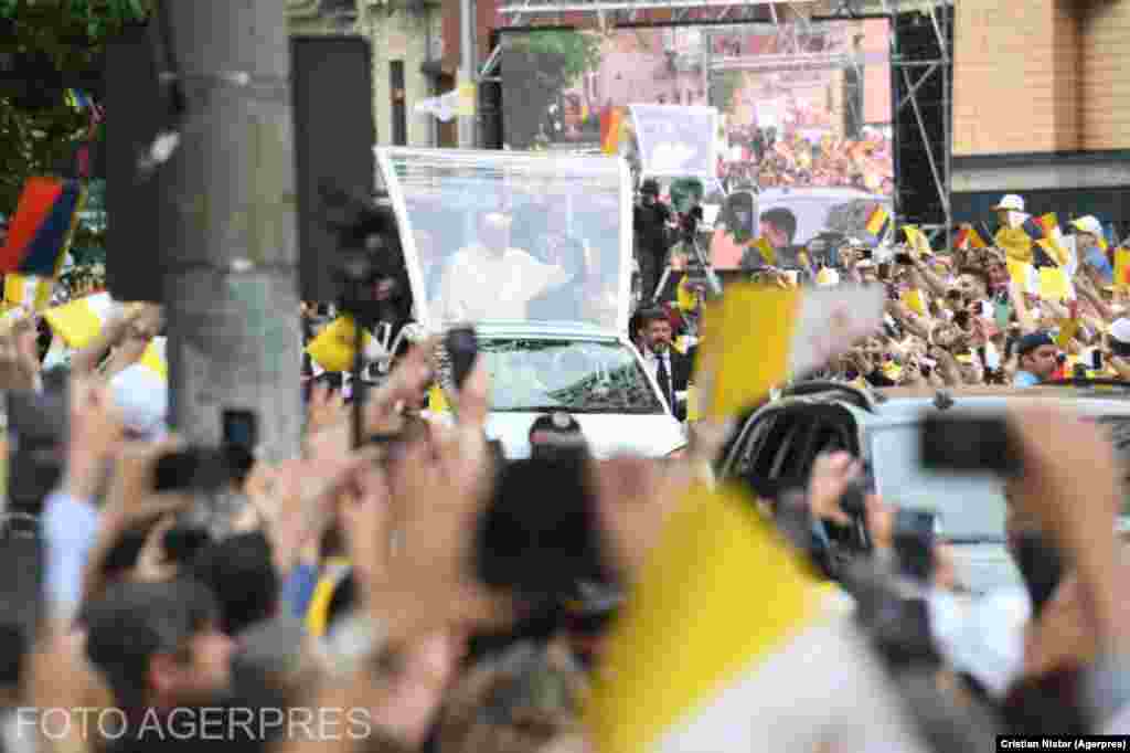 Papa Francisc le face cu mâna din Papamobil miilor de oameni care au venit să îl vadă