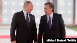 Russian President Vladimir Putin (left) and his Uzbek counterpart, Shavkat Mirziyoev, attend a welcoming ceremony in Tashkent on October 19.
