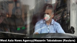 A bus driver wearing a protective mask to prevent contracting coronavirus, as he drives the bus in Tehran, Iran February 25, 2020.