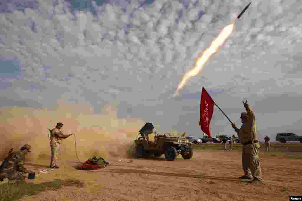 Iraqi Shi'ite fighters fire a rocket during clashes with Islamic State militants on the outskirts of Alam. (Reuters/Thaier al-Sudani)