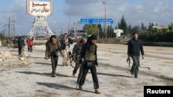 Rebel fighters walk in December around the Al-Hamidiyeh base, one of two military posts they took control of from government forces in the northwestern province of Idlib.