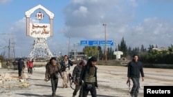 Rebel fighters walk around al-Hamidiyeh base, one of two military posts they took control of from government forces in the northwestern province of Idlib, in December.