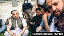 Amrullah Saleh (L) surrounded by his supporters after the attack 