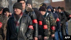 Crimean pro-Russian volunteers line up in a square in front of a statue of Vladimir Lenin in Simferopol on March 14.