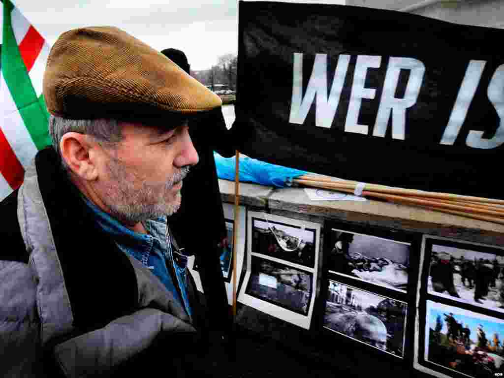 Austria -- Ali Israilov [father of Umar] - epa01609082 Ali Israilov stands looks at pictures and a banner saying 'Who's next' during a manifestation in memory of Chechen Umar Israilov, a former Chechen rebel and bodyguard to Chechen President Ramzan Kadyrov who was shot dead in Vienna on 20 January in Vienna, Austria, 22 January 2009. Umar Israilov came public with allegations of torture. EPA/Rene Van Bakel