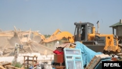 Бульдозер разрушает дома в поселке Бакай близ Алматы. 7 июля 2009 года.
