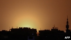На фото, зробленому з контрольованої повстанцями Думи, видно світло вогню від вибуху біля аеропорту Дамаска, Сирія, 27 квітня 2017 року