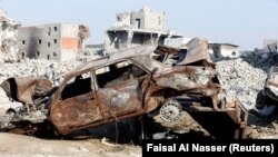 Remains of a car and buildings are seen in the town of Awamiya, in the eastern part of Saudi Arabia August 9, 2017