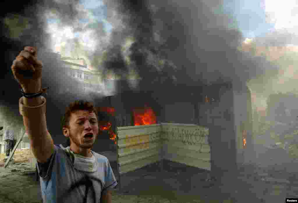 An antigovernment protester shouts in front of a burning container on Istanbul's Taksim Square on June 4.
