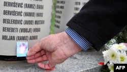 Ramiz Holjan, otac Admira Holjana, ubijenog tokom opsade Sarajeva, ostavlja njegovu fotografiju na spomen-obilježje djeci ubijenoj tokom opsade, Sarajevo, 14. mart 2016.