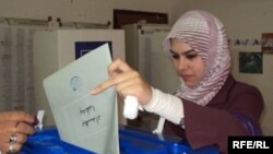  یک زن عراقی روز یکشنبه رای خود را در بغداد به صندوق می‌اندازد.
