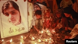 Children light oil lamps at a school in Peshawar beside a picture of Malala Yousafzai, who was shot on October 9 by Taliban militants for speaking out against them and promoting education for girls.