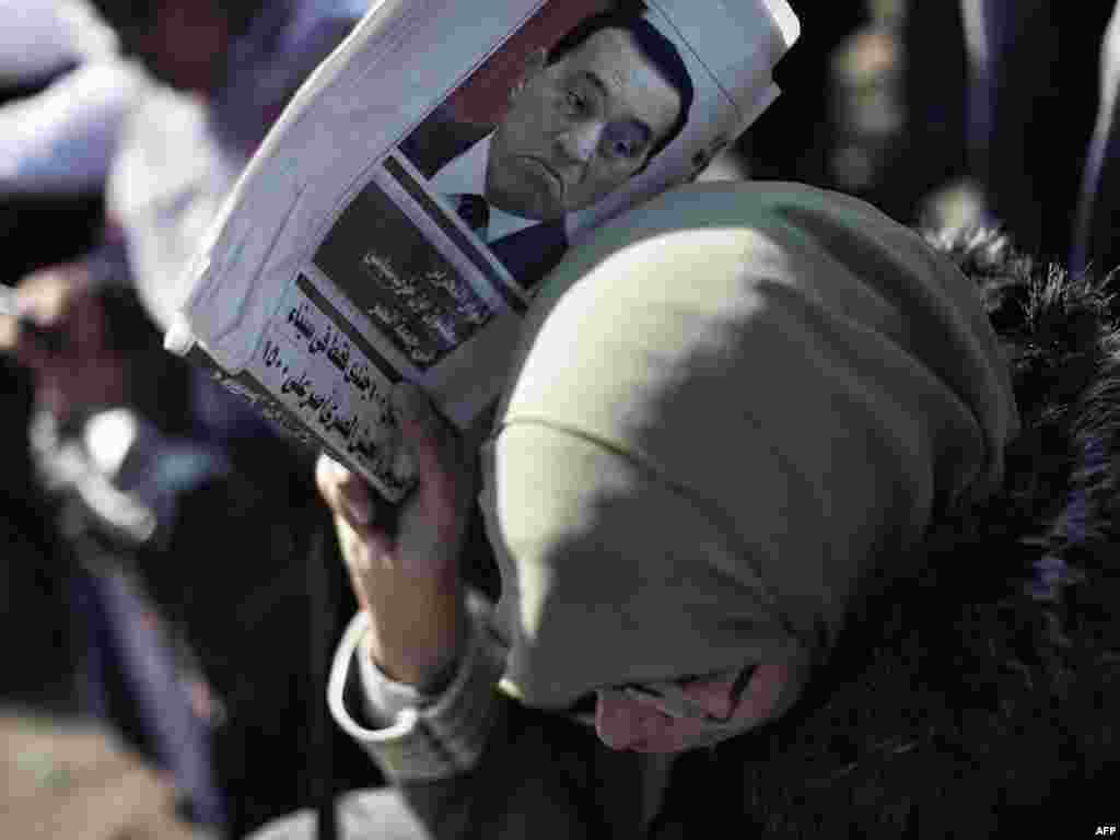 An Egyptian woman shields herself from the sun with a newspaper bearing a portrait of Egypt's deposed president, Hosni Mubarak, during celebrations on February 18 in Cairo's landmark Tahrir Square, marking one week after Mubarak, who ruled Egypt for nearly 30 years, was forced out of office by an unprecedented wave of protests in the Arab world's most populous country.Photo by Marco Longari for AFP