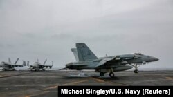 AT SEA -- An F/A-18E attached to the "Sidewinders" of Strike Fighter Squadron (VFA) 86 makes an arrested landing on the flight deck of the aircraft carrier USS Abraham Lincoln (CVN 72), in the Gulf, in this picture taken and released by U.S. Navy on Augus
