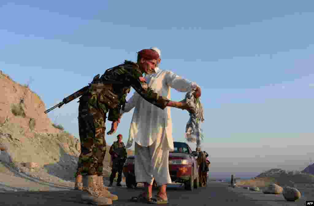 Під час Рамадану в багатьох країнах прийнято влаштовувати для сусідів і друзів-мусульман урочисті іфтари &ndash; ритуали вечірнього розговіння На фото &ndash; солдат афганської народної армії обшукує чоловіка напередодні свята Ураза-Байрам