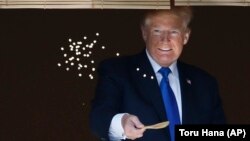 Президент США Дональд Трамп кормит карпов во дворце Акасака накануне рабочего завтрака с премьер-министром Японии Синдзо Абэ