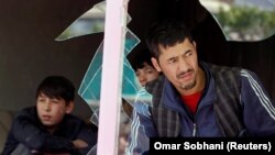 An Afghan men look out through a broken window at the site of a suicide attack in Kabul on April 22.