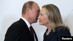 Russian President Vladimir Putin greets then-U.S. Secretary of State Hillary Clinton upon her arrival at an APEC summit in Vladivostok in 2012.