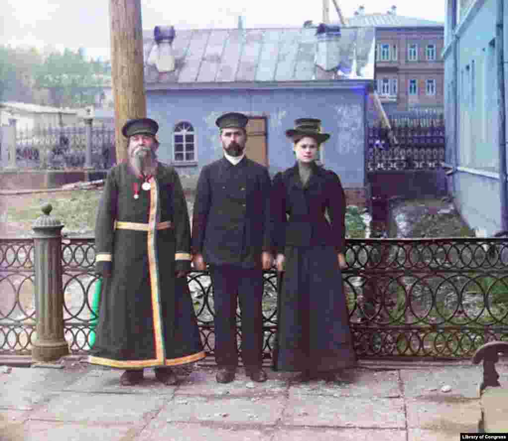 A.P. Kalganov with his son and granddaughter in the industrial town of Zlatoust in the Urals - In this portrait of three generations, the grandfather wears traditional Russian dress, while his son and granddaughter, both employees of a local armaments factory, display more modern, Westernized dress and hairstyles.