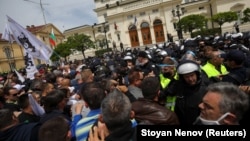 Supporters of the Revival party scuffle with police during an anti-government protest in front of the parliament in Sofia in May 2020.