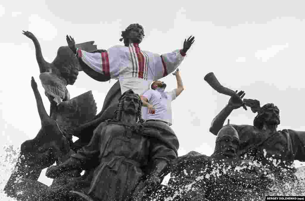 A man puts Ukraine's national costume, the Vyshyvanka, on a statue commemorating Kyiv's city founders on May 19, the day Ukrainians dedicate to their national dress. (epa/Sergey Dolzhenko) 