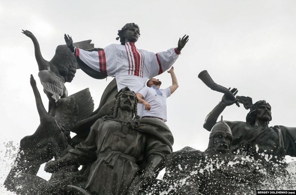 Një njeri i veshur me kostume kombëtare të Ukrainës, e Vyshyvanka, hipur në një statujë, në ditën kur Kievi përkujton themeluesit më 19 maj.&nbsp;