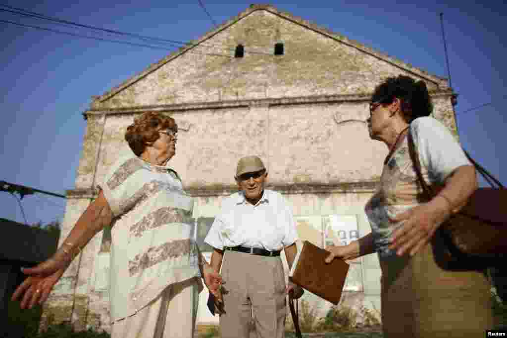  Lucija Rajner (left), Marijana Sibinovic, and Teodor Kovac at the site where their fathers were interned during World War II. Many people have expressed anger at the development plans for the former camp.