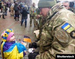 Дівчинка спілкується з бійцем-добровольцем батальйону «Київ-12». Столиця України, 6 грудня 2014 року