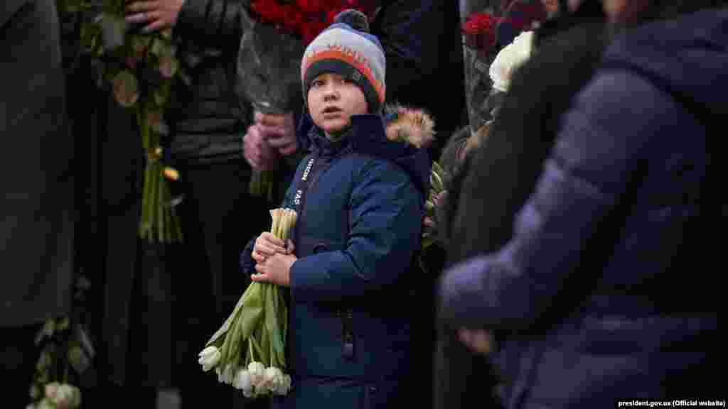 A young boy holds flowers during the memorial service at Boryspil airport.