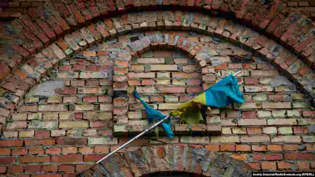 A Ukrainian flag hangs on the bell tower of a church in the middle of Pisky.