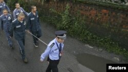 Китайский полицейский и заключенные. Иллюстративное фото.