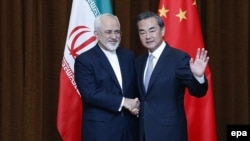 Chinese Foreign Minister Wang Yi (right) waves to photographers with his Iranian counterpart Javad Zarif in Beijing in 2015.