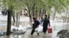 Afghan men carry their belongings as they evacuate from their residential area after flash flooding in the west of Kabul on April 16. 