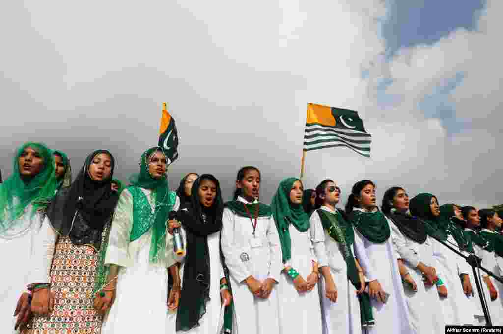 Pakistani women sing their country&#39;s national anthem with Kashmir&#39;s flag to express solidarity with the people of the disputed region during a ceremony to celebrate Pakistan&#39;s 72nd Independence Day in Karachi on August 14. (Reuters/Akhtar Soomro)