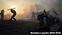 UKRAINE -- Ukrainian servicemen fire a towed howitzer close to a frontline near the village of Novoluhanske village, Donetsk region, January 11, 2018