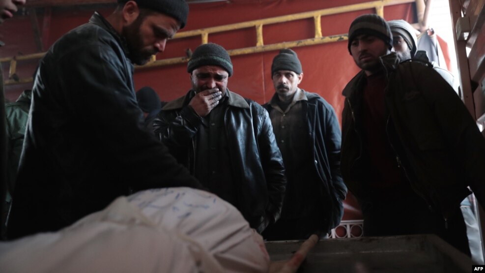 A man cries over the body of his 18-year-old son at a makeshift morgue in the rebel-held town of Douma, on the eastern outskirts of Damascus, following a reported air strike targeting the city on December 28.