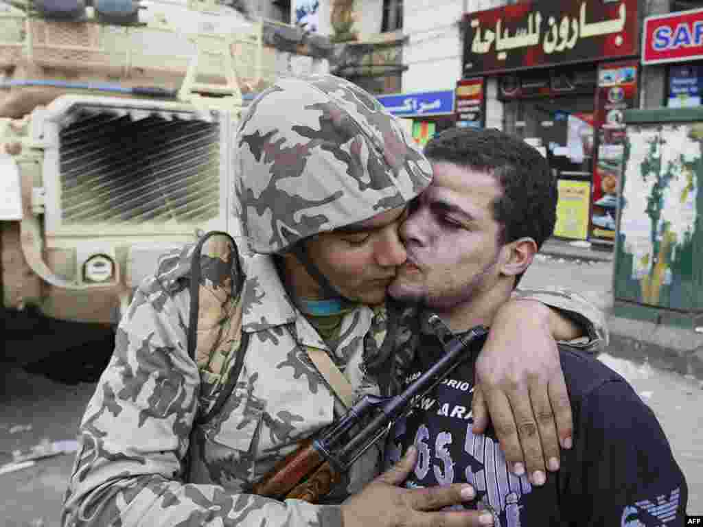 A civilian kisses an army soldier after troops took positions at major junctions in central Cairo on January 29.