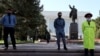 KYRGYZSTAN -- Police officers in face masks stand guard at the monument to Vladimir Lenin in the center of Bishkek, April 22, 2020