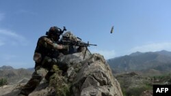 An Afghan security force personnel fires during an ongoing an operation against Islamic State (IS) militants in the Achin district of Nangarhar province on April 11