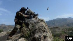 A member of the Afghan security forces fires during an ongoing operation against Islamic State (IS) militants in the Achin district of Nangarhar Province in April.