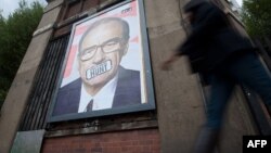 Un poster cu figura lui Rupert Murdoch afișat pe o stradă londoneză