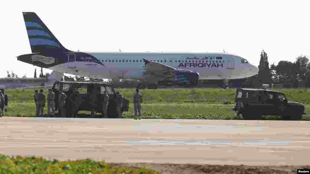 Maltese troops survey a hijacked Libyan Afriqiyah Airways Airbus A320 on the runway at Malta Airport