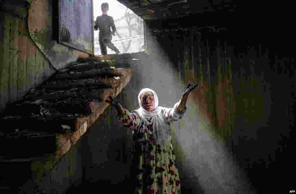 A woman reacts while walking among the ruins of damaged buildings following heavy fighting between government troops and Kurdish fighters in the southeastern Kurdish town of Cizre in Turkey, near the border with Syria and Iraq on March 2. (AFP/Yasin Akgul)