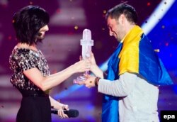 Conchita Wurst înmînînd premiul Eurovision 2015 la Viena