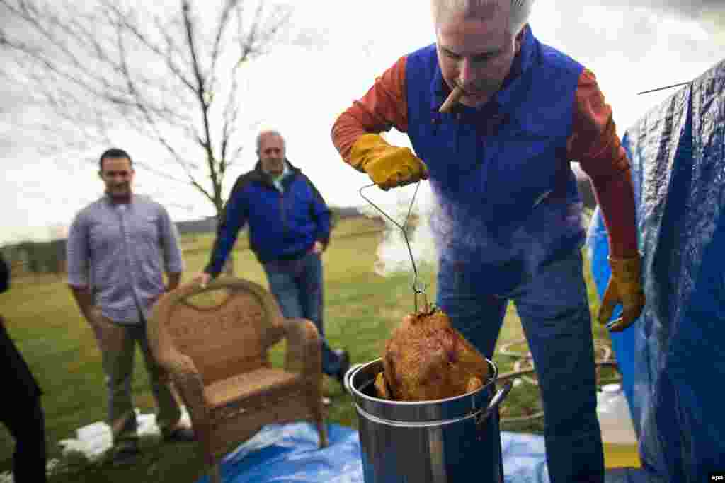 A man pulls a deep-fried turkey out of a pot of peanut oil on Thanksgiving Day outside Leesburg, Virginia. (epa/Jim Lo Scalzo)