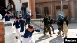 FILE: Schoolchildren flee as army soldiers conducting an exercise to repel militant attacks detain a mock-militant (R) at the Islamia Collegiate School in Peshawar.