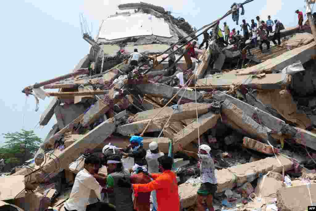 Bangladeshi volunteers and rescue workers are pictured at the scene after an eight-story building collapsed in Savar, on the outskirts of Dhaka. At least 190 people died in the disaster. (AFP/Munir uz Zaman)