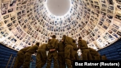 Ізраїльські солдати дивляться на фотографії жертв Голокосту в музеї в Єрусалимі, 26 січня 2014 року